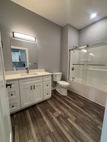 a spacious bathroom with a double vanity sink a mirror and a toilet