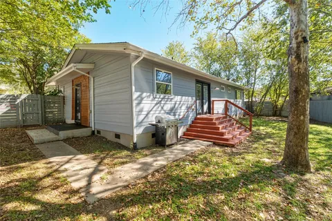 a view of a house with backyard and a tree