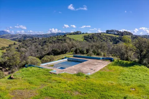 an aerial view of residential houses with outdoor space and swimming pool