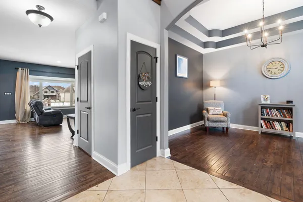 a view of a hallway with wooden floor and a living room