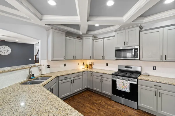 a kitchen with a sink cabinets and wooden floor