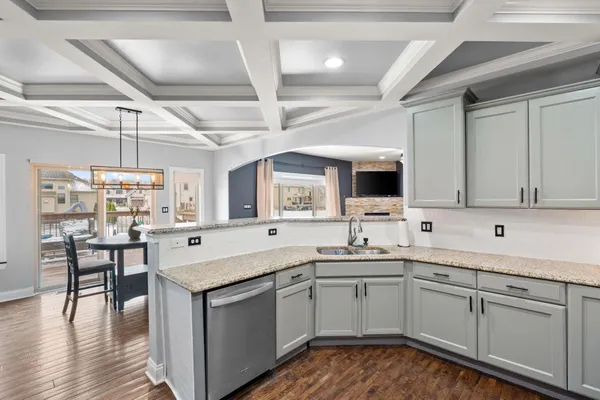 a kitchen with granite countertop a refrigerator and wooden cabinets
