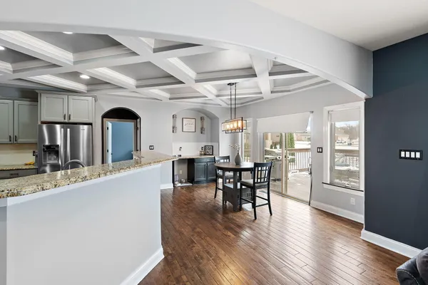 a view of a kitchen with kitchen island a window a appliances and chairs