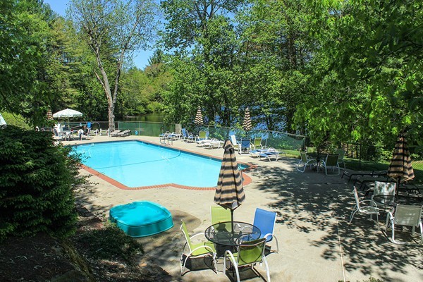 230 Winding Pond Road, Unit 230 Londonderry, NH 03053 - Photo 24 of 30 a view of a swimming pool with a patio and fire pit