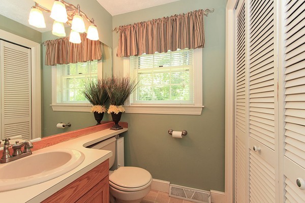 230 Winding Pond Road, Unit 230 Londonderry, NH 03053 - Photo 9 of 30 a bathroom with a sink a toilet and a window