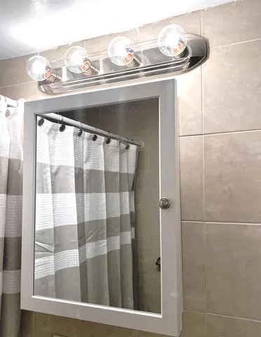 a bathroom with a mirror and a shower