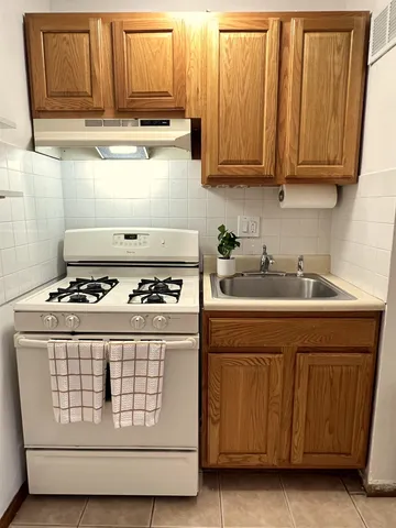 a white stove top oven sitting inside of a kitchen