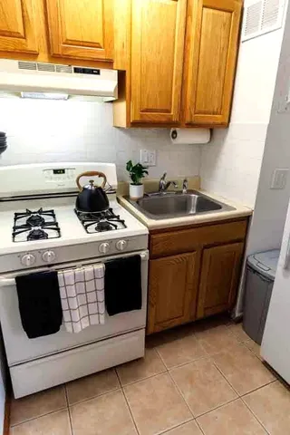 a white stove top oven sitting inside of a kitchen