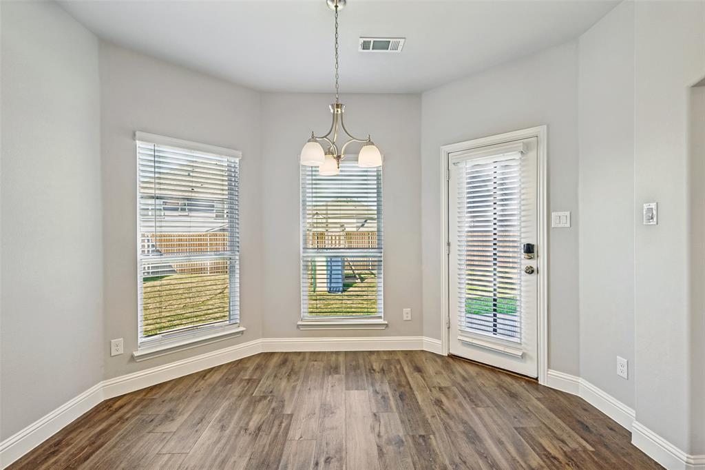 212 Wandering Way Anna, TX 75409 - Photo 15 of 36 a view of an empty room with wooden floor and a window