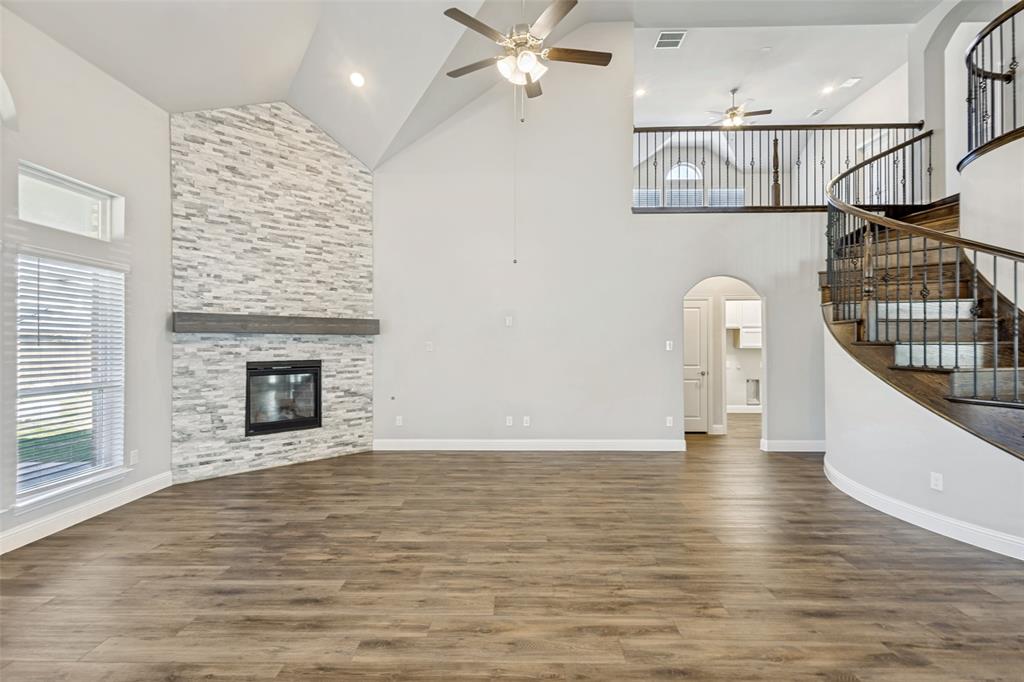 212 Wandering Way Anna, TX 75409 - Photo 17 of 36 an empty room with wooden floor fireplace and windows