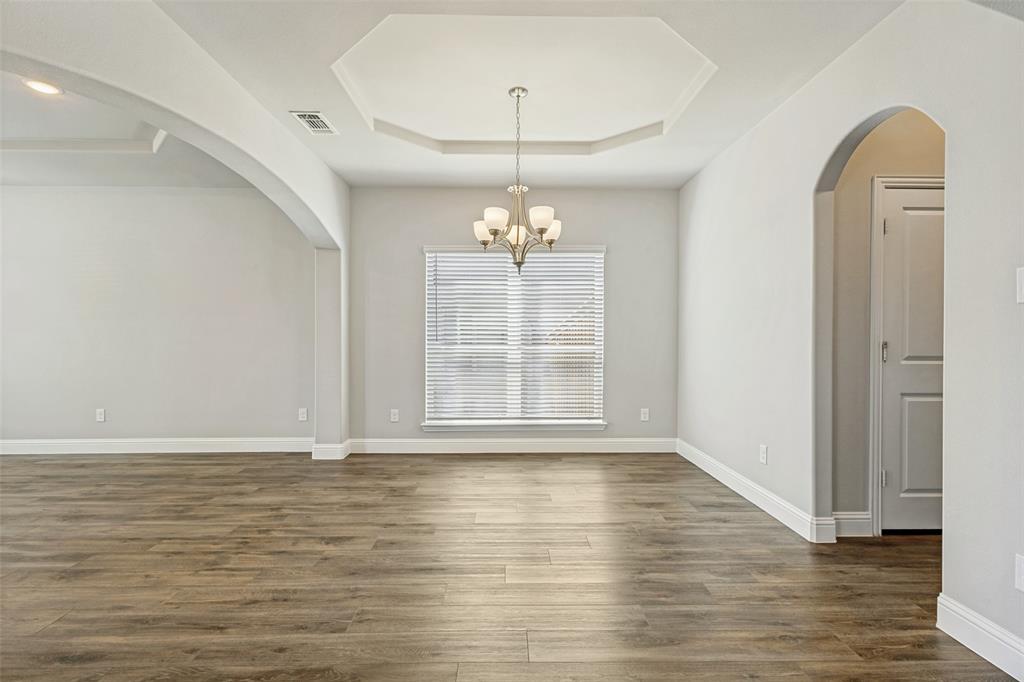 212 Wandering Way Anna, TX 75409 - Photo 7 of 36 a view of an empty room with wooden floor and a window