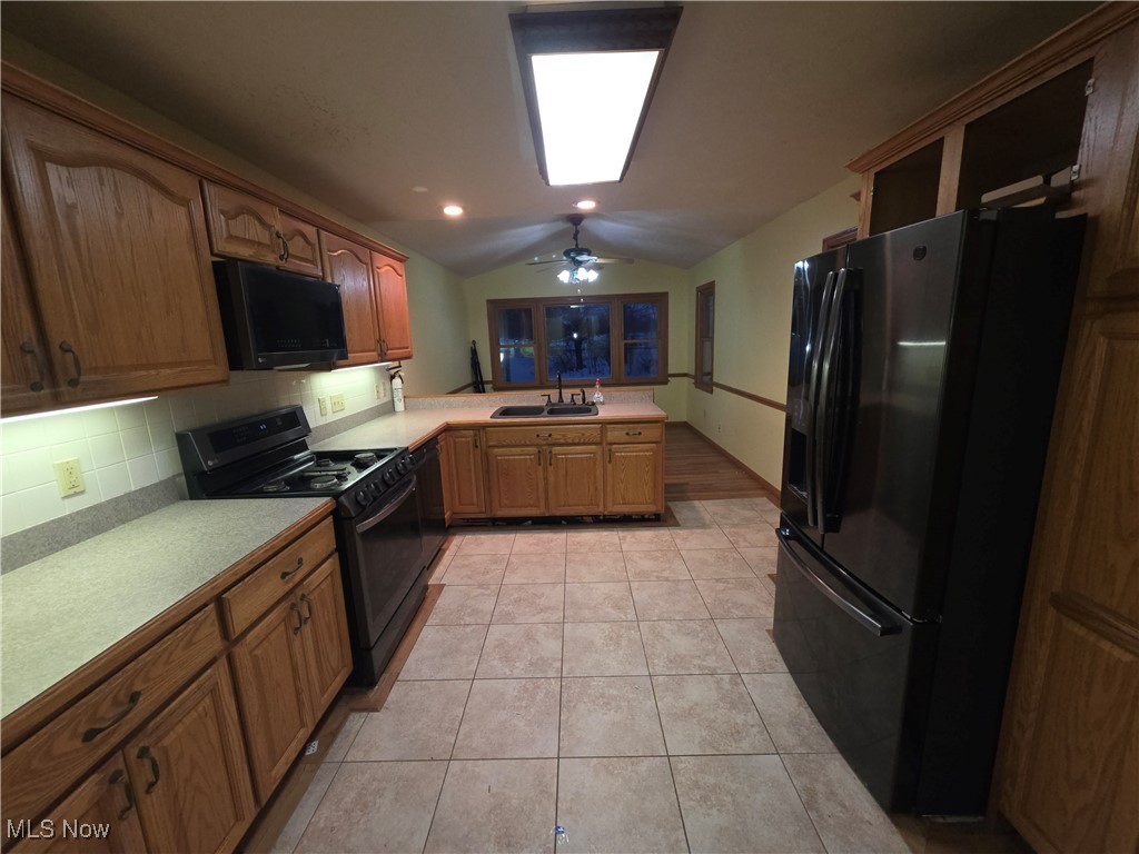 2291 Armstrong Road Wooster, OH 44691 - Photo 9 of 23 Kitchen with black appliances, vaulted ceiling, light countertops, wood finish cabinets, breakfast nook