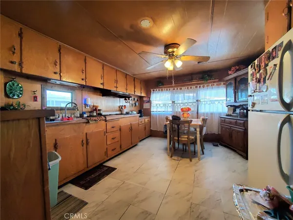 a kitchen with stainless steel appliances kitchen island granite countertop a table chairs in it and a window