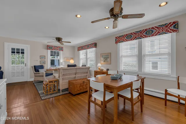 a kitchen with a sink dishwasher and white cabinets with wooden floor