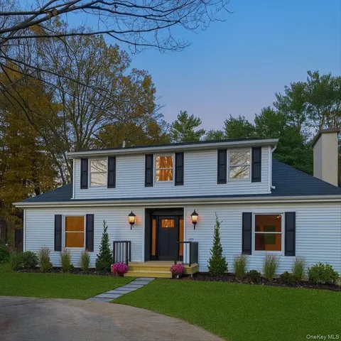 a front view of a house with a yard and trees