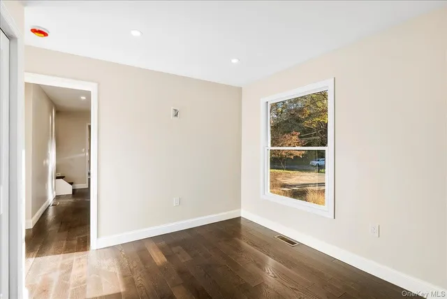an empty room with wooden floor and closet
