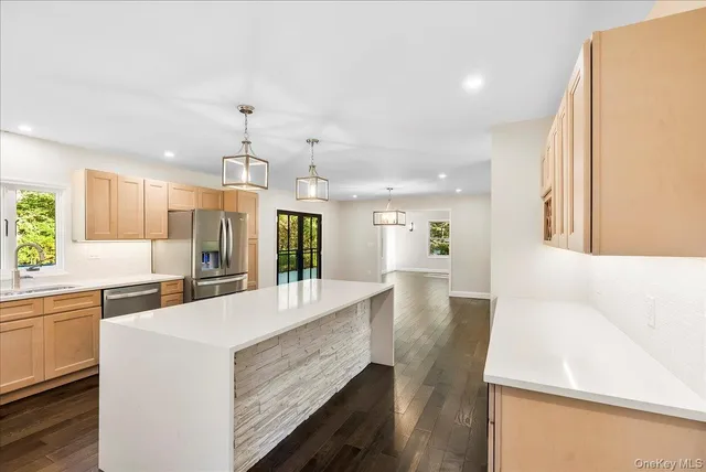 a kitchen with stainless steel appliances a refrigerator sink and wooden floor