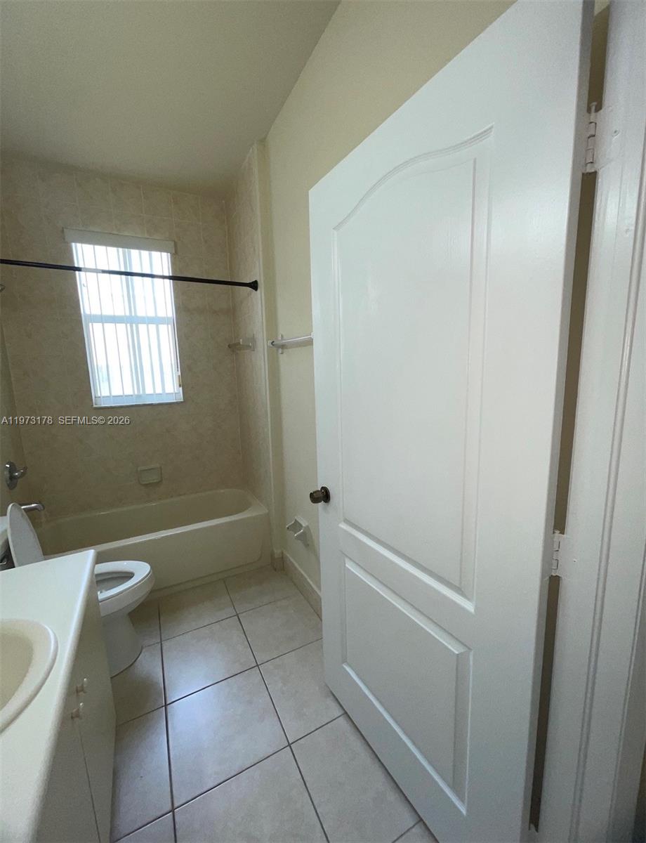 1661 Southeast 29th Court, Unit 109 Homestead, FL 33035 - Photo 11 of 18 a bathroom with a granite countertop bathtub and toilet