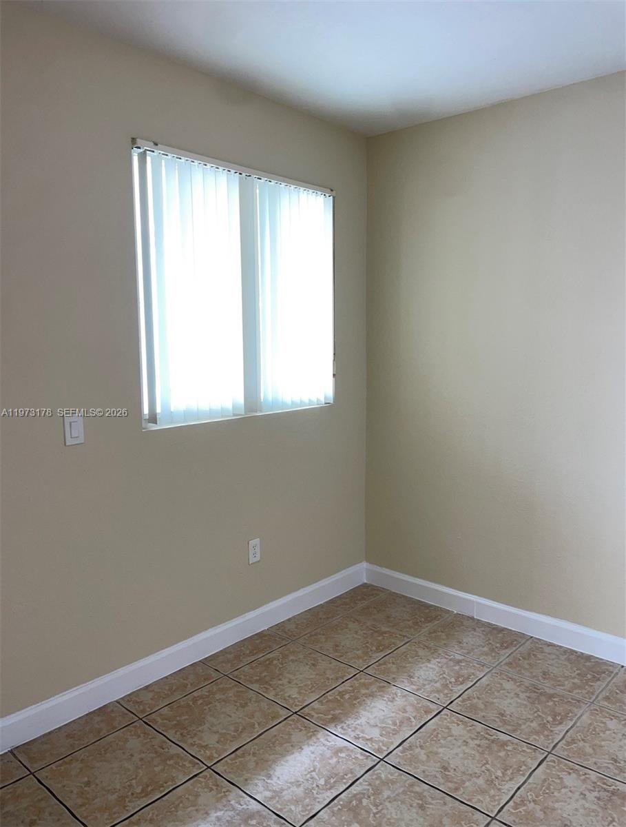 1661 Southeast 29th Court, Unit 109 Homestead, FL 33035 - Photo 17 of 18 an empty room with a window