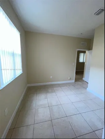 a view of a livingroom with an empty space and a window