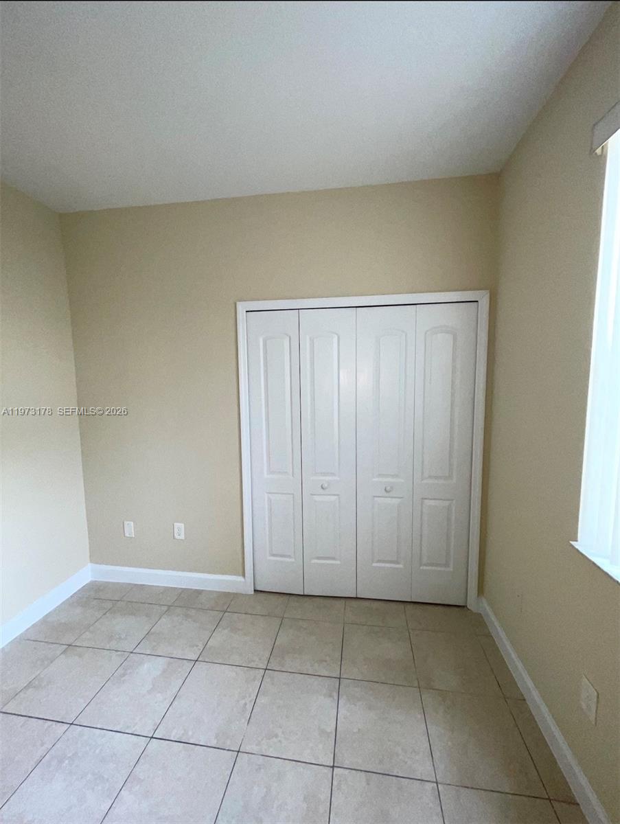 1661 Southeast 29th Court, Unit 109 Homestead, FL 33035 - Photo 6 of 18 a view of an empty room and window