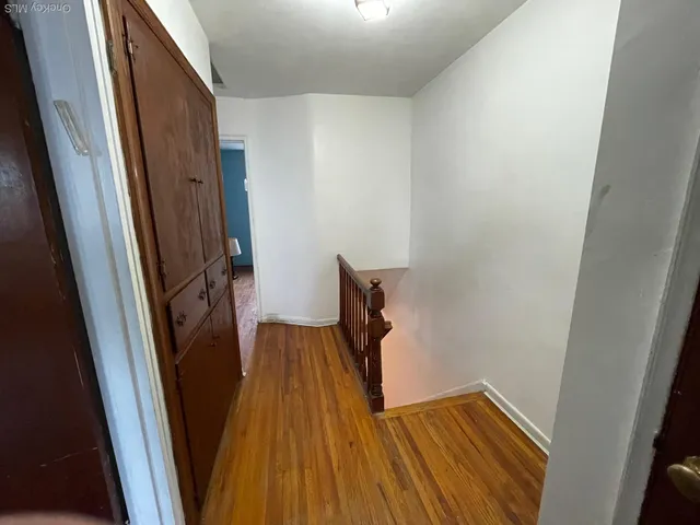 a view of a hallway with wooden floor and stairs