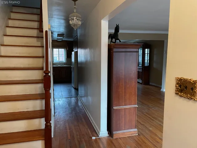 a view of a hallway with wooden floor and staircase