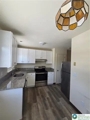 a kitchen with stainless steel appliances granite countertop a refrigerator a stove a sink and a microwave