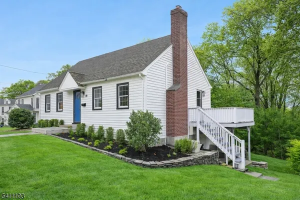 a aerial view of a house next to a big yard and large trees