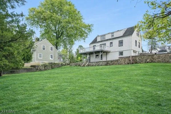 a view of a house with a big yard and large trees