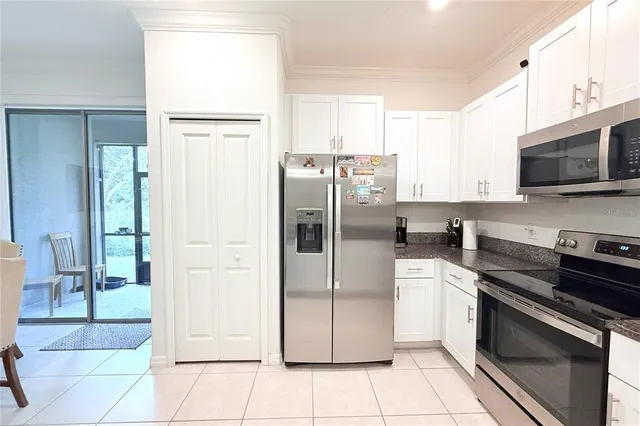 a kitchen with stainless steel appliances granite countertop a refrigerator a stove a sink and a microwave