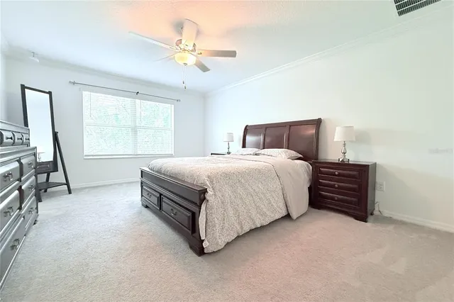 a spacious bedroom with a bed a chandelier and a window
