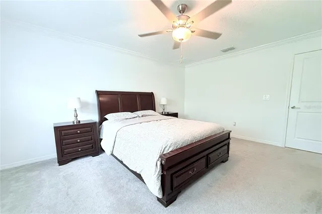 a spacious bedroom with a bed and a chandelier