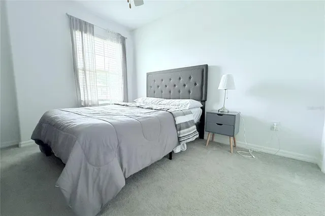 a bed sitting in a bedroom next to a window