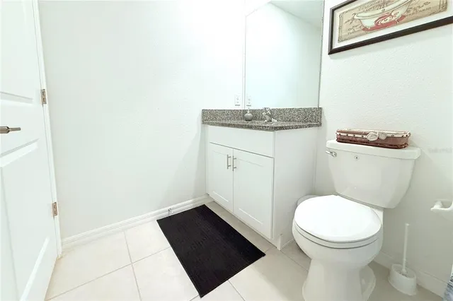 a bathroom with a granite countertop toilet and a sink