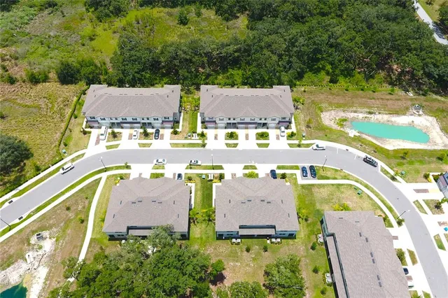 an aerial view of residential houses with outdoor space and swimming pool