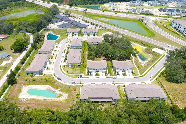 an aerial view of residential houses with outdoor space and swimming pool