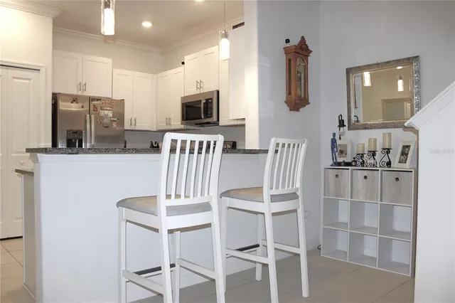 a kitchen with stainless steel appliances kitchen island granite countertop a refrigerator and microwave