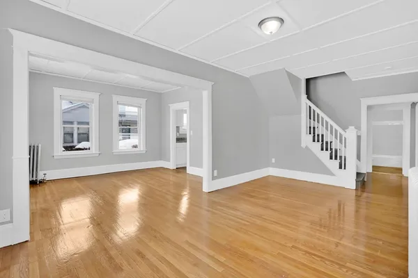 a view of empty room with wooden floor