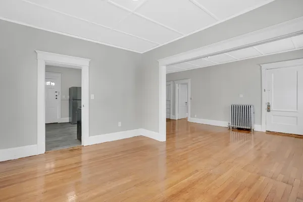 a view of an empty room with wooden floor