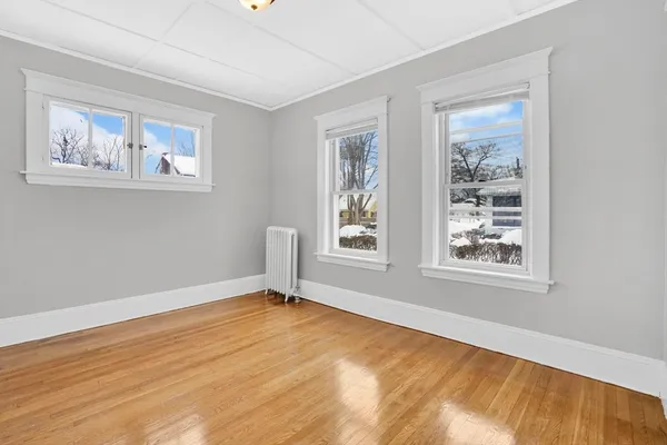 a view of empty room with wooden floor and window