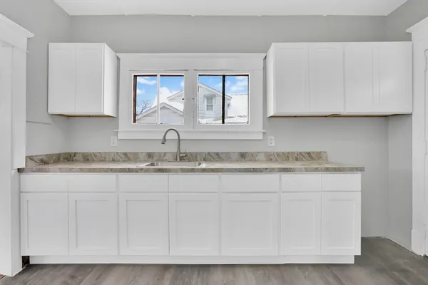 a kitchen with granite countertop white cabinets and a stainless steel appliances