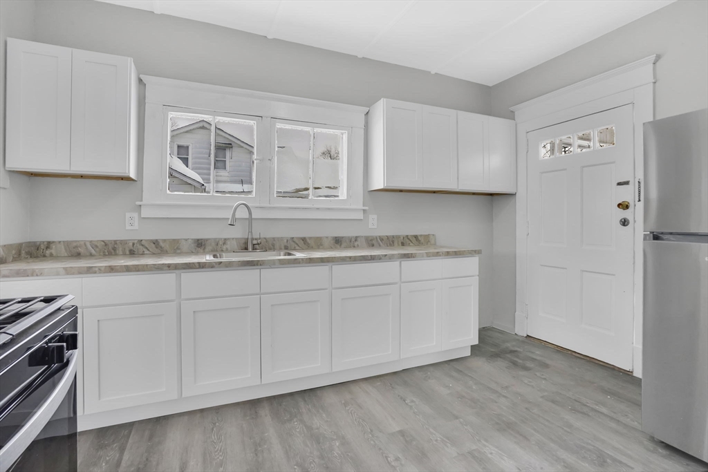 11 Ina Street Springfield, MA 01109 - Photo 3 of 23 a kitchen with granite countertop white cabinets and a stainless steel appliances