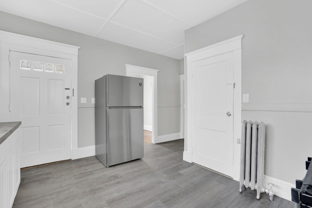 11 Ina Street Springfield, MA 01109 - Photo 4 of 23 an empty room with wooden floor and a hallway