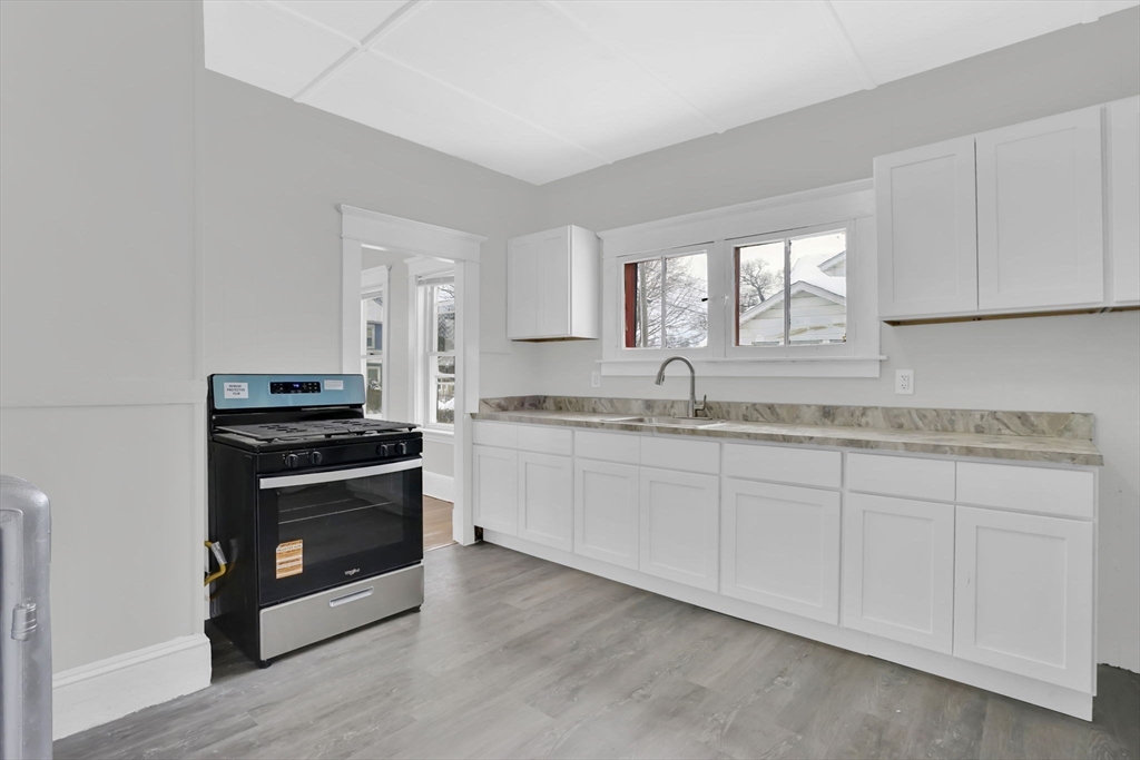 11 Ina Street Springfield, MA 01109 - Photo 5 of 23 a kitchen with granite countertop a stove a sink and a microwave