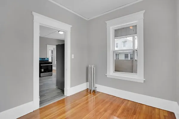 a view of a small space with wooden floor and a window