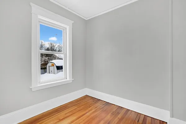 a view of empty room with wooden floor