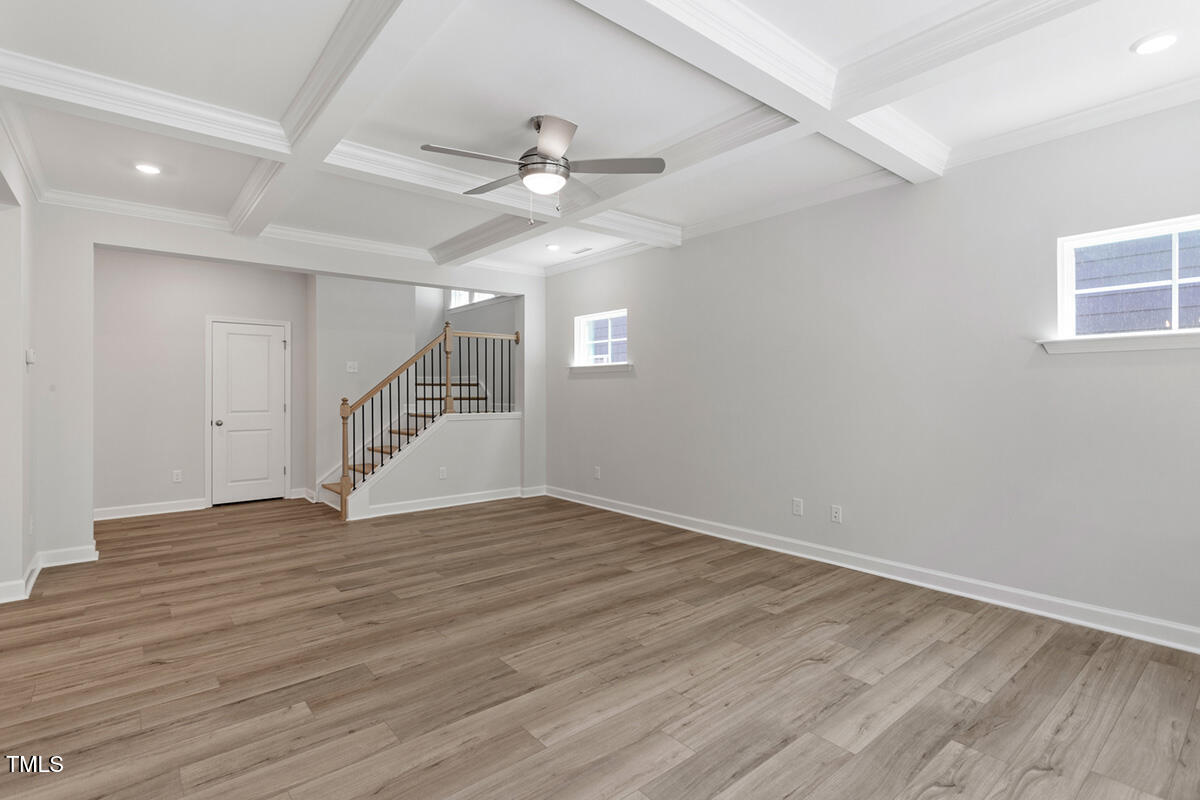 119 Augusta Pond Way, Unit 147 Raleigh, NC 27603 - Photo 11 of 37 an empty room with wooden floor fan and windows