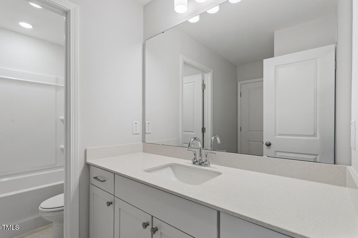 119 Augusta Pond Way, Unit 147 Raleigh, NC 27603 - Photo 20 of 37 a bathroom with a sink and a mirror
