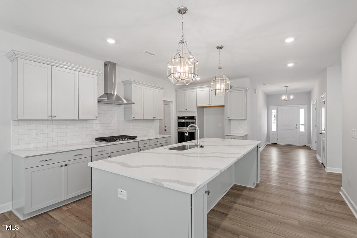 119 Augusta Pond Way, Unit 147 Raleigh, NC 27603 - Photo 7 of 37 a large kitchen with granite countertop a stove a sink a island and windows